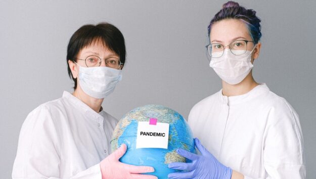 people-with-face-masks-and-latex-gloves-holding-a-globe-4167561